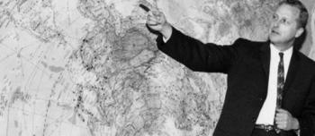 Image of Dr. Borchert pointing at a map on the wall